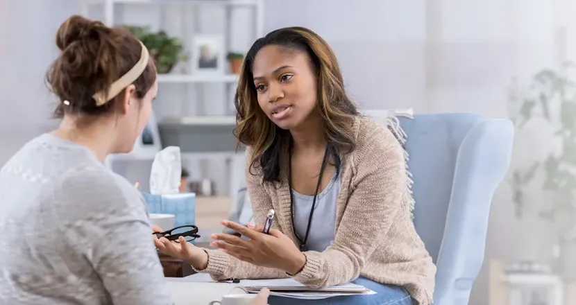 Substance Abuse Counselor with Psychology Degree Smiling with Client